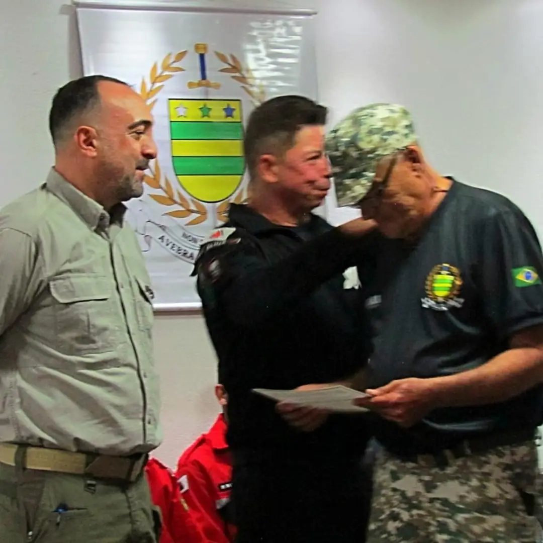 Instrutor entregando distintivo a aluno durante a brevetação