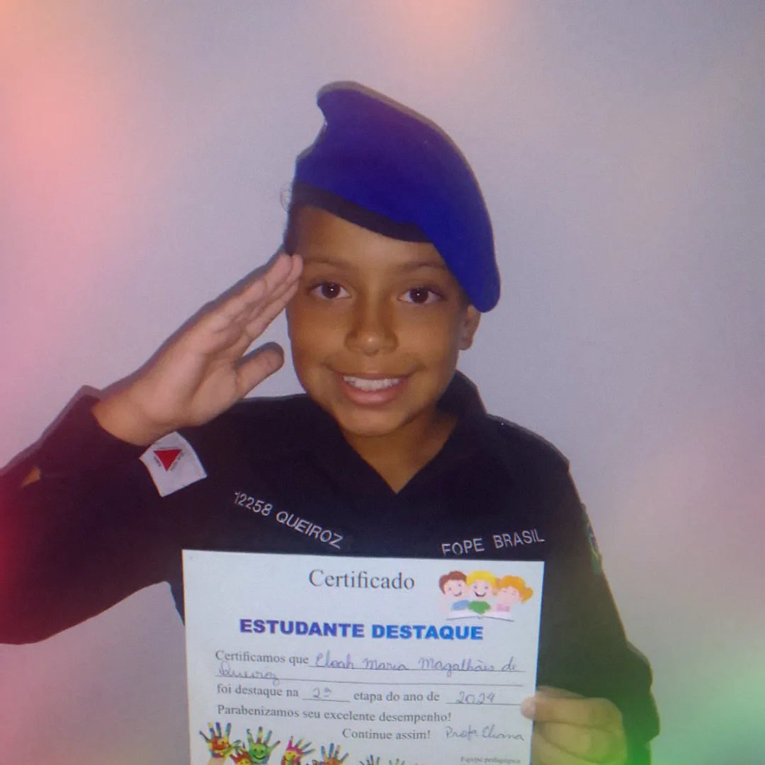 Aluna prestando continência segurando certificado de estudante destaque